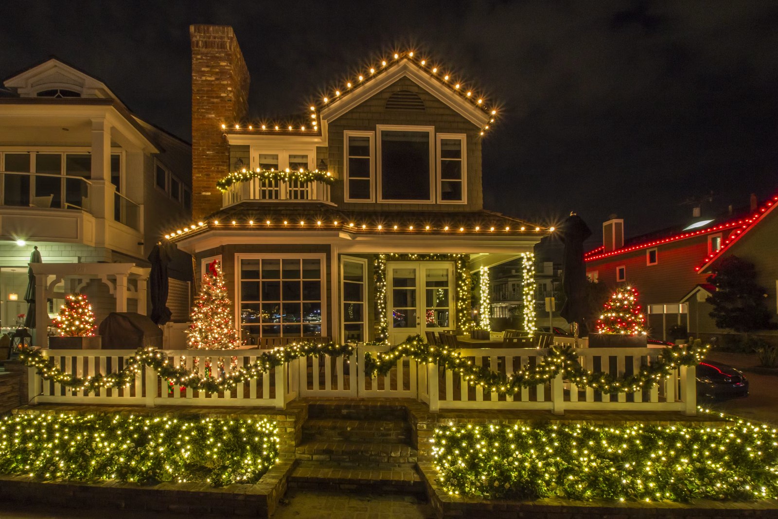 Cottage with C9 roofline lights, garland, and picket fence